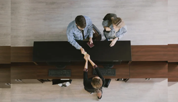 How to evaluate hotel software for your property in 2025 - two hotel guests check into a hotel from a bird's eye view - Sabre Hospitality