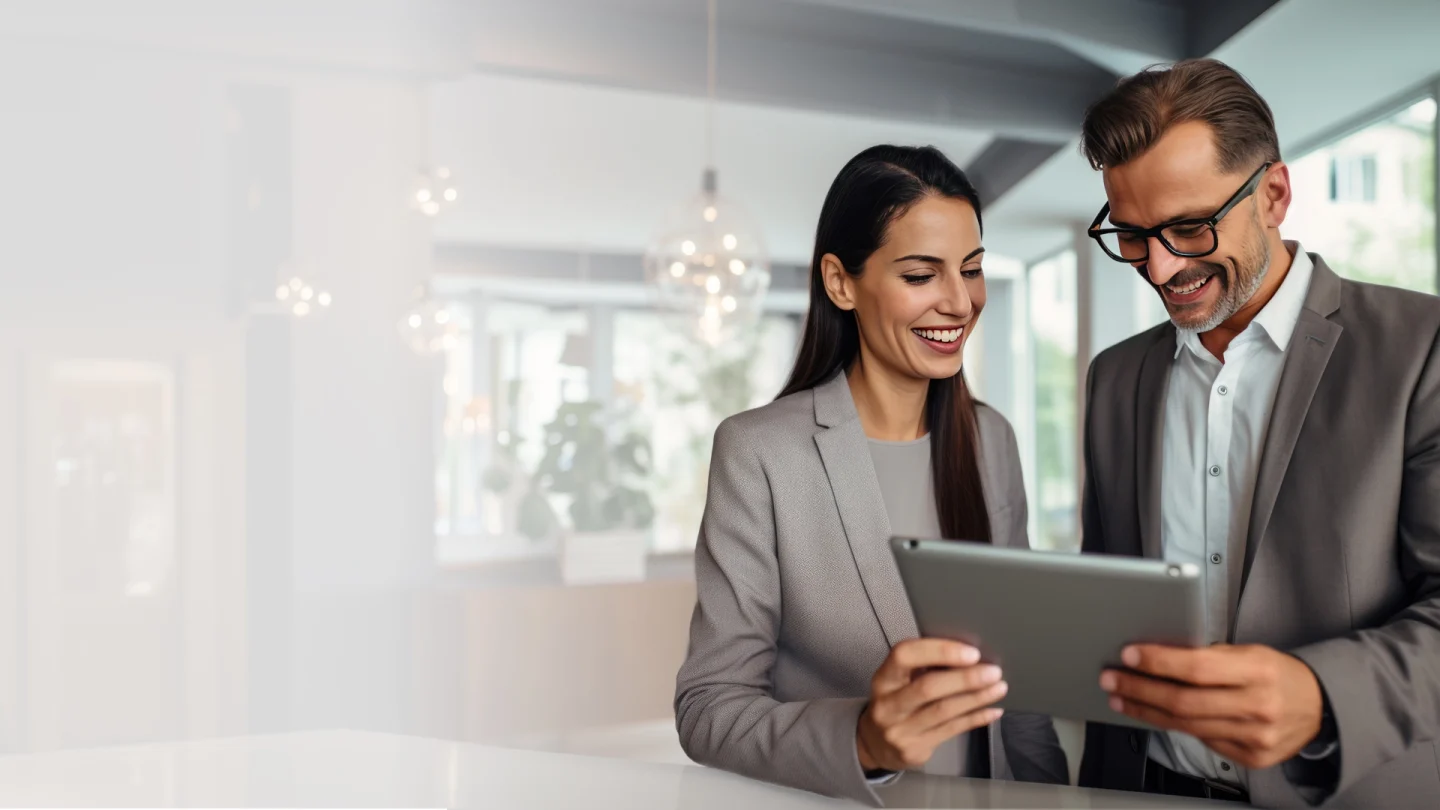 Hospitality and hotel marketing insights and trends - A man and a woman look at an iPad, smiling - Hospitality Solutions