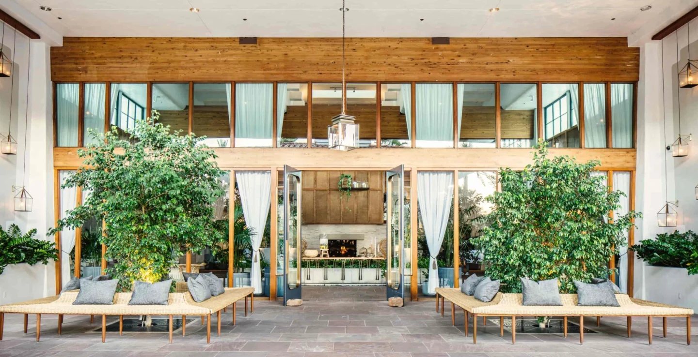 How Marc & Rose Hospitality scaled guest offerings and revenue with a smarter retailing strategy - An outside patio at a hotel with trees and benches - Sabre Hospitality