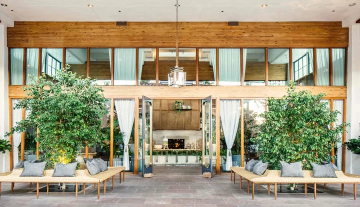 How Marc & Rose Hospitality scaled guest offerings and revenue with a smarter retailing strategy - An outside patio at a hotel with trees and benches - Sabre Hospitality