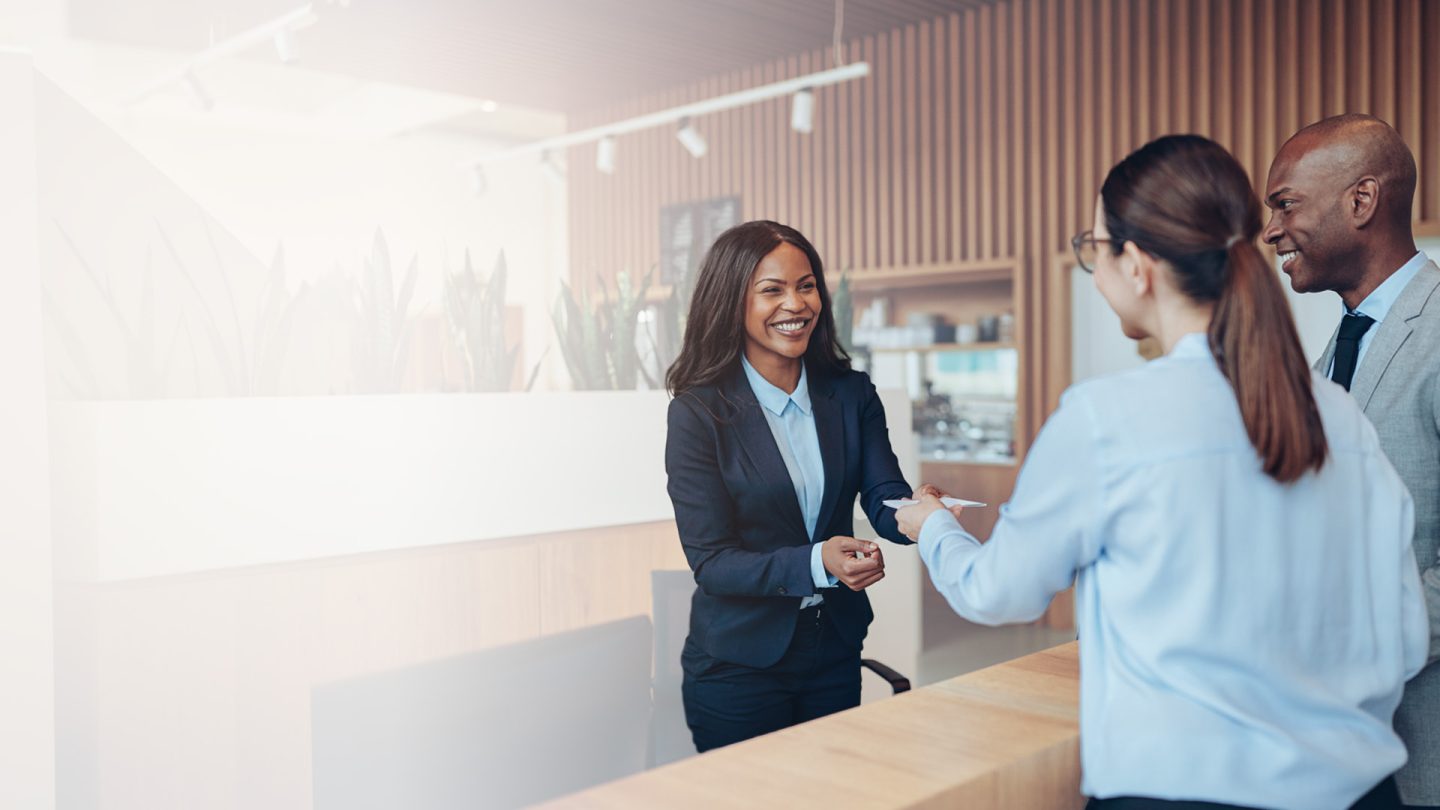 Strategies to Increase Hotel Revenue - Sabre Hospitality - Image of couple checking into hotel.